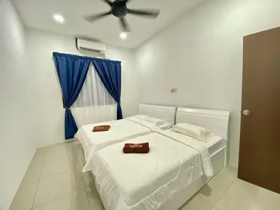 a bedroom with two beds and a ceiling fan at Rumah Inap Che'Gu Baha in Teluk Intan