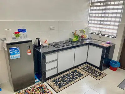 a kitchen with a stove and a refrigerator at Rumah Inap Che'Gu Baha in Teluk Intan