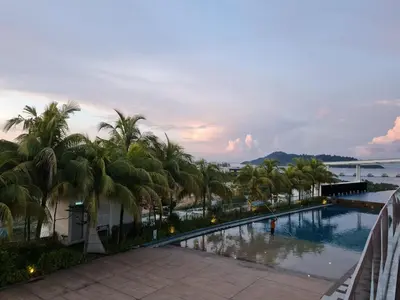 a view of a swimming pool with palm trees at Seaview Condo 10pax #10minQueensbay #15minSpice in Bayan Lepas