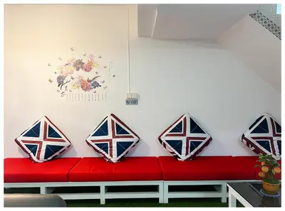 a red couch with four pillows on a wall at ✩ 23 HOUSE ✩ 23号 复古老宅 ✩ Vintage Homestay in Butterworth