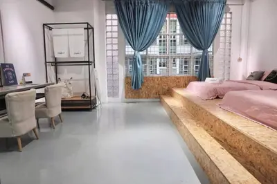 a bedroom with a large bed and a table and chairs at Studio S Conceptual Homestay Station 18 - Ipoh in Ipoh