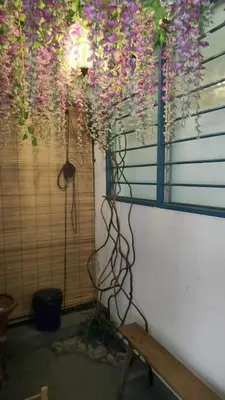 a room with flowers hanging from a window and a bench at Comfy Home Near to Penang Hill in Ayer Itam