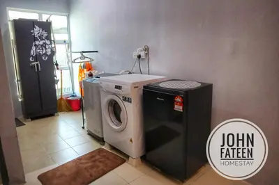 a laundry room with a washing machine and a washer at lumut manjung homestay john faten in Lumut