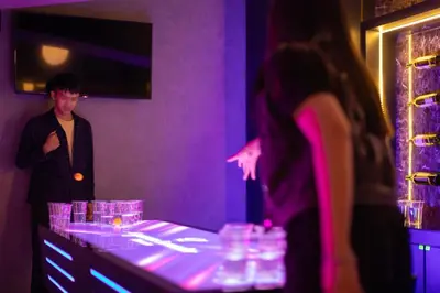 a man standing in a purple room with a table with glasses at Cameron Lavender Mansion by PLAY in Brinchang