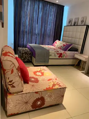a room with two beds and a ottoman in it at Aiera Homestay @ Meru Casa Kayangan in Ipoh