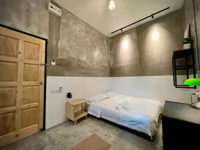a bedroom with a bed and a wooden door at DoSomething Guest House 5 in Ipoh