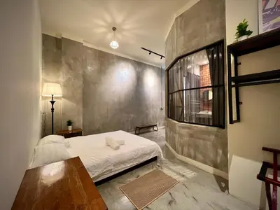 a bedroom with a white bed and a wall at DoSomething Guest House 3 in Ipoh