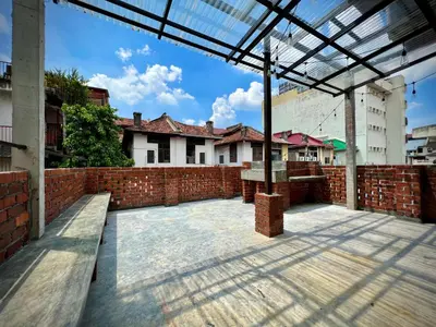 an empty courtyard with a brick wall and benches at DoSomething Guest House 3 in Ipoh