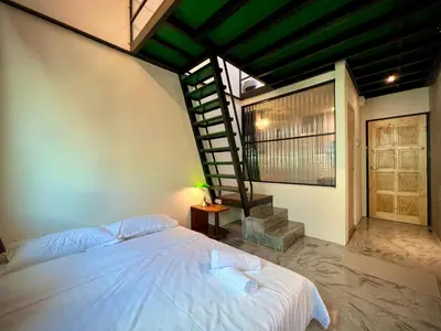 a bedroom with a white bed and a staircase at DoSomething Guest House 1 in Ipoh