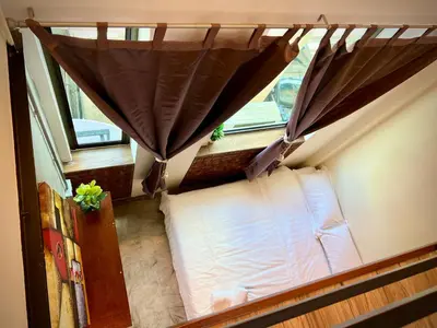 a small room with a bed and a window at DoSomething Guest House 1 in Ipoh