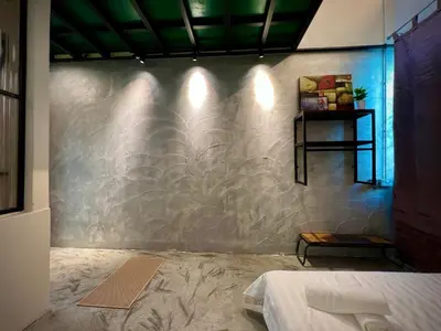 a room with a wall that has a stone wall at DoSomething Guest House 1 in Ipoh