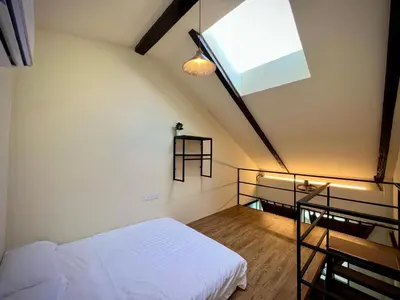 a bedroom with a white bed and a skylight at DoSomething Guest House 1 in Ipoh