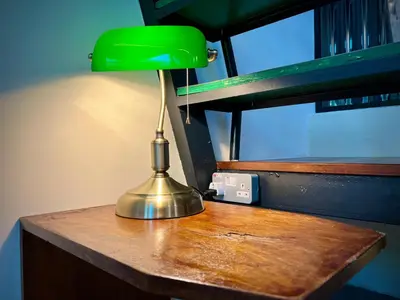 a green lamp sitting on top of a wooden table at DoSomething Guest House 1 in Ipoh
