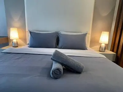a bed with a pillow on it with two lamps at Deluxe Seaview Suite King Bed by The Only Bnb in Tanjong Tokong
