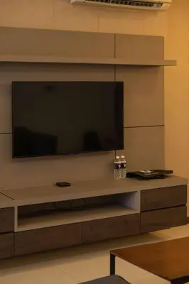 a large television on a wall in a living room at Deluxe Seaview Suite King Bed by The Only Bnb in Tanjong Tokong