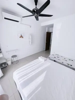 a white room with a bed with a ceiling fan at Manhanttan Ipoh Waterpark Homestay By Warmth Stay 4-7pax 3BR in Ipoh