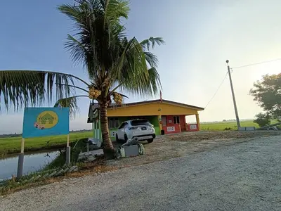 a car parked in front of a building with a palm tree at Laman D'Arni in Sungai Besar