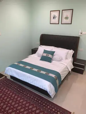 a bedroom with a large bed with two pictures on the wall at Puncak Villa 10-20pax in Kuala Kangsar