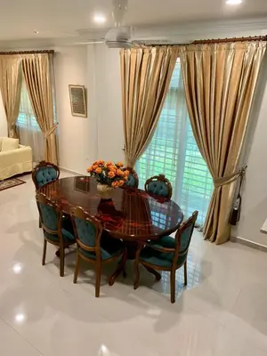 a dining room table and chairs in a living room at Puncak Villa 10-20pax in Kuala Kangsar
