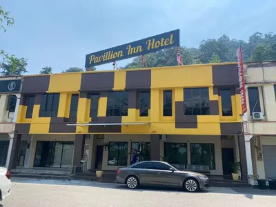 a car parked in front of a yellow and black building at Hotel O Pavilion Inn Hotel in Lumut