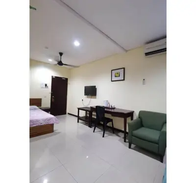 a room with a bed and a desk and a chair at Hotel O Pavilion Inn Hotel in Lumut
