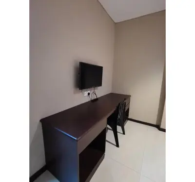 a desk with a television on top of it in a room at Hotel O Pavilion Inn Hotel in Lumut