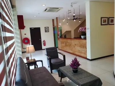 a living room with a couch and a table at Hotel O Pavilion Inn Hotel in Lumut