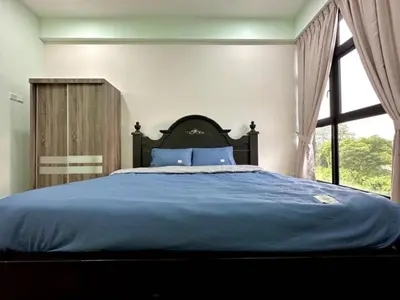 a bedroom with a large blue bed with a window at Ipoh Simple Homestay by Comfort Home in Ipoh