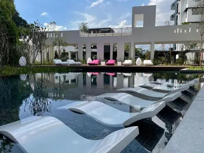 a swimming pool with white chairs in front of a building at Ipoh Simple Homestay by Comfort Home in Ipoh