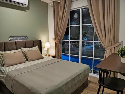 a bedroom with a bed and a table and a window at Paddy Villea Inn SPT Penang in Permatang Pauh