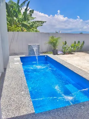 a swimming pool with a water fountain at Paddy Villea Inn SPT Penang in Permatang Pauh