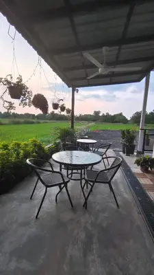 a patio with two tables and chairs and a table at Paddy Villea Inn SPT Penang in Permatang Pauh
