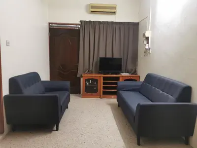 a living room with two blue couches and a television at Homestay Taman Mas, Kg Koh in Sitiawan