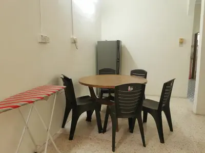 a table and chairs in a room with a refrigerator at Homestay Taman Mas, Kg Koh in Sitiawan