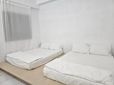 two beds in a room with white walls at Fukuda Minshuku Japanese style in Lumut