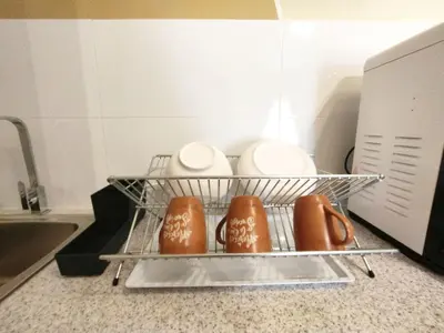 a dish rack with plates and cups in a microwave at The Horizon Ipoh Stay by Grab A Stay in Ipoh