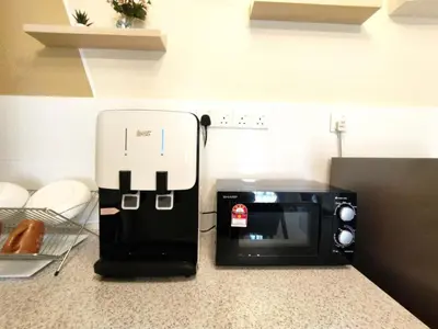 a microwave sitting on top of a kitchen counter at The Horizon Ipoh Stay by Grab A Stay in Ipoh