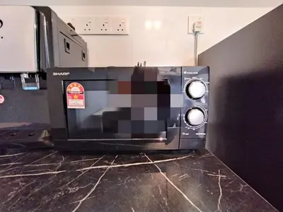 a microwave oven sitting on top of a counter at The Horizon Ipoh Stay by Grab A Stay in Ipoh