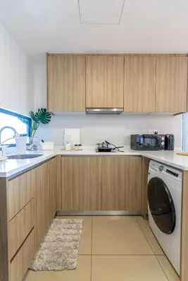 a kitchen with wooden cabinets and a washer and dryer at Momento Stay Georgetown 10pax \u4e54\u6cbb\u5e02\u4e2d\u5fc3-\u6d77\u666f\u623fSeaview Room in George Town