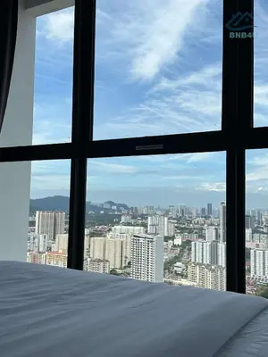 a bedroom with a view of a city from a window at Urban Suites Georgetown by BNB4U in Jelutong