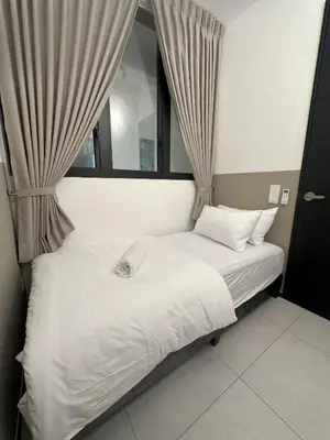 a bedroom with a white bed with a window at Urban Suites Georgetown by BNB4U in Jelutong