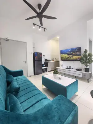 a living room with a blue couch and a table at The Horizon - Ipoh in Ipoh