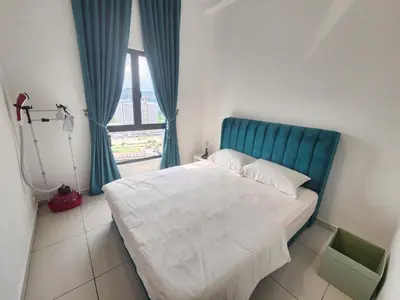 a bedroom with a bed with a blue headboard and a window at The Horizon - Ipoh in Ipoh