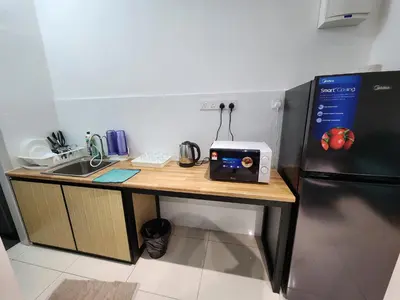 a kitchen with a counter with a sink and a refrigerator at Ipoh City Executive Suite - The Horizon in Ipoh