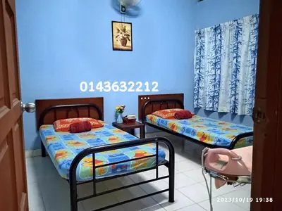 two beds in a room with blue walls at Ekaira homestay in Tambun