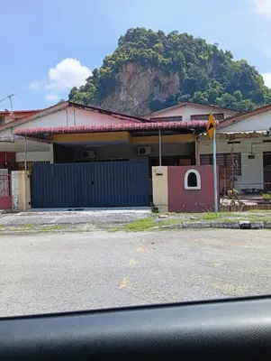 a building with a mountain in the background at Ekaira homestay in Tambun