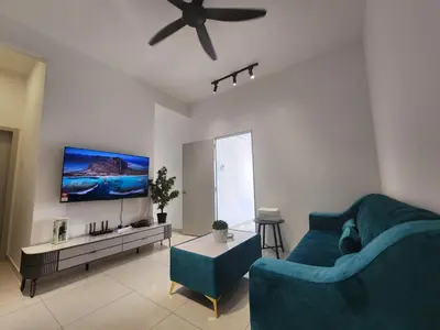 a living room with a blue couch and a flat screen tv at Horizon Premium Suite - Ipoh in Ipoh