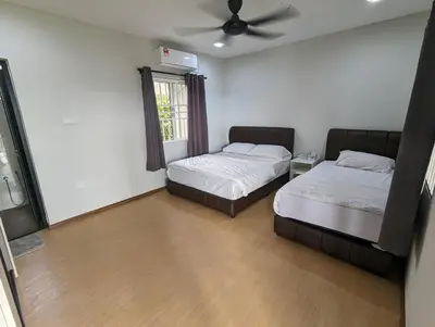 a bedroom with two beds and a ceiling fan at Villa with Titiwangsa Hill View in Kerling