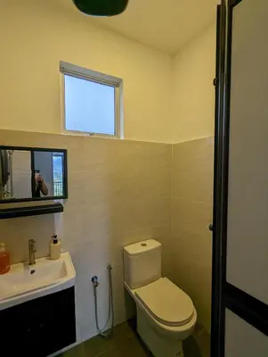 a bathroom with a toilet and a sink and a person taking a picture at Villa with Titiwangsa Hill View in Kerling