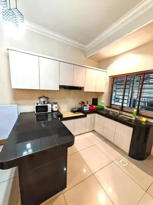 a kitchen with white cabinets and a black counter top at GWarmStay@GoldenHillsNightMarket in Brinchang